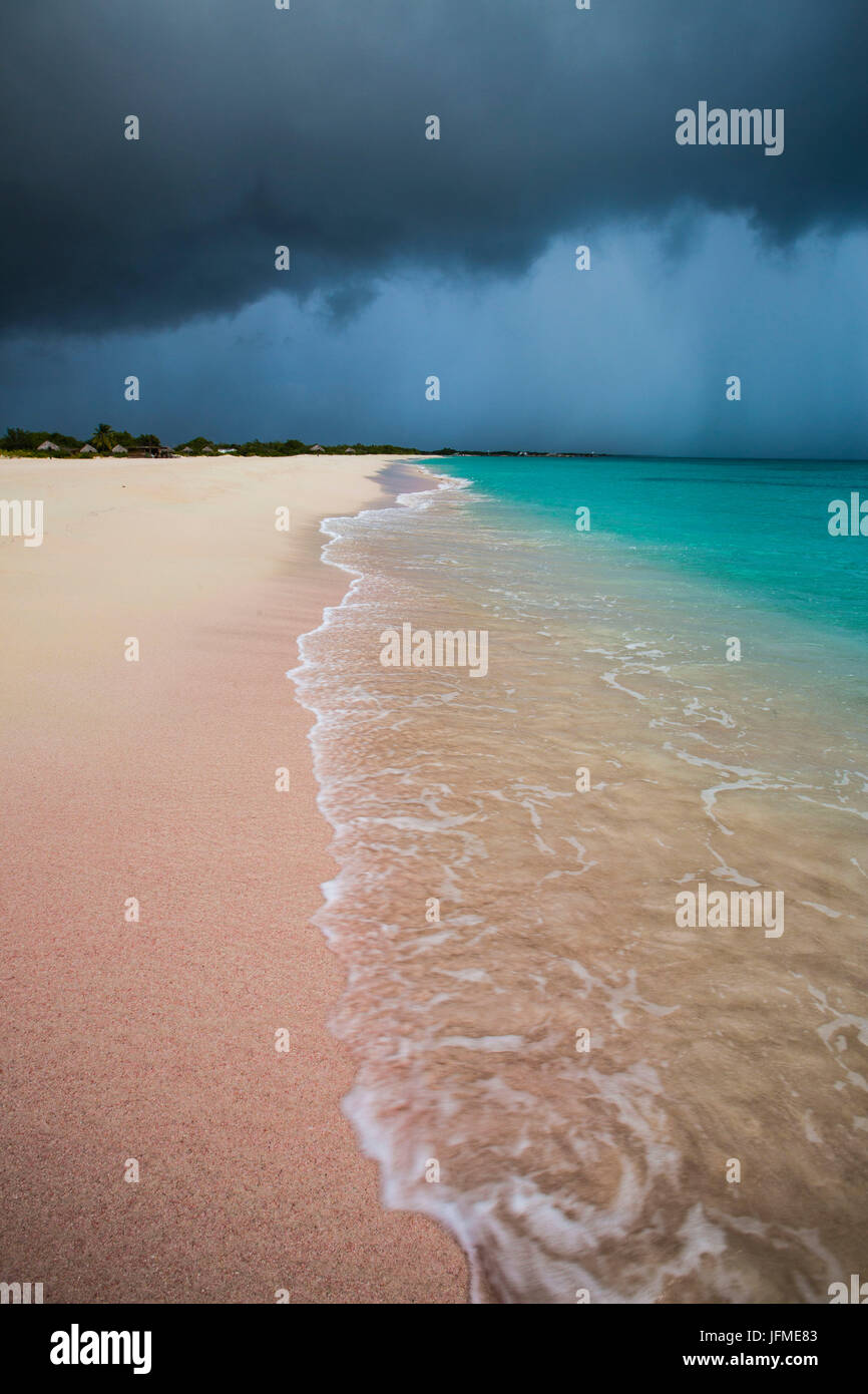 Storm clouds on fine sand framed by the turquoise sea Pink Sand Beach Antigua and Barbuda Leeward Islands West Indies Stock Photo