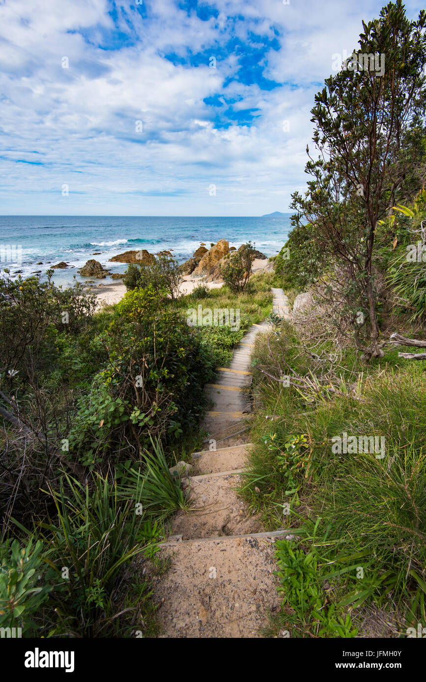 A narrow sandy path leads to blue skies and the golden sands of a back beach at Hallidays Point on the New South Wales north coast Stock Photo