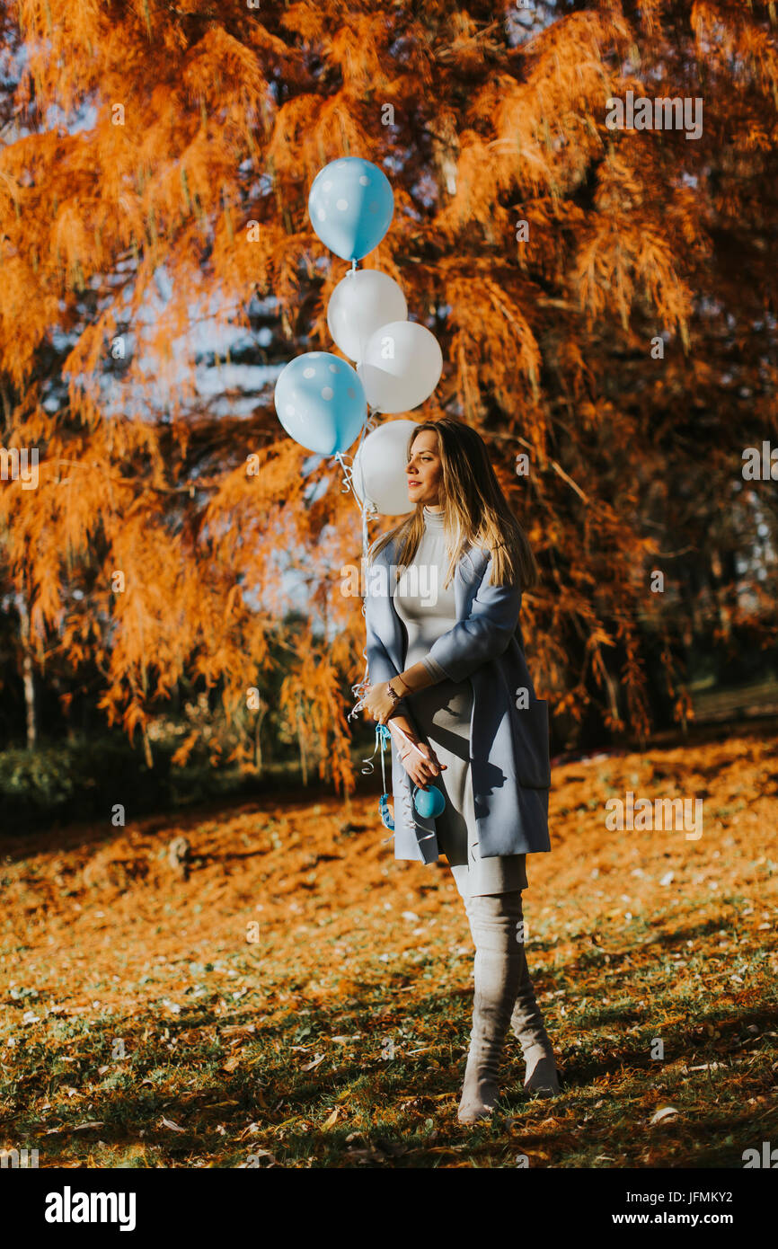 Young pregnant woman walks in autumn park with balloons in hand Stock ...