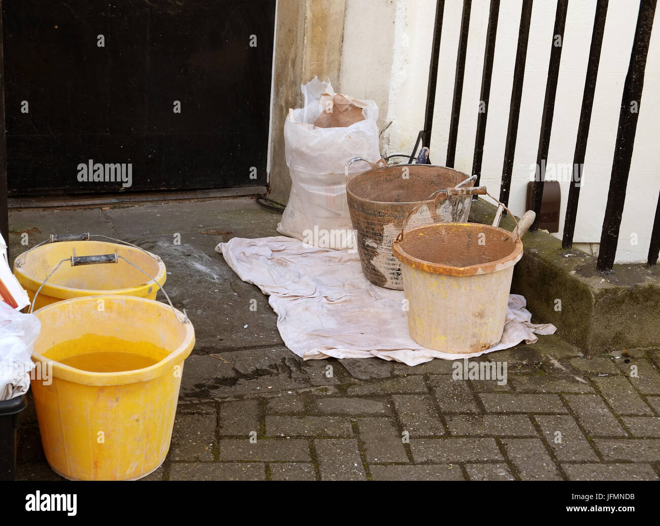 March 2015 - Plasterers buckets and tools outside the front door of a large London city residential home which is being refurbished. Stock Photo