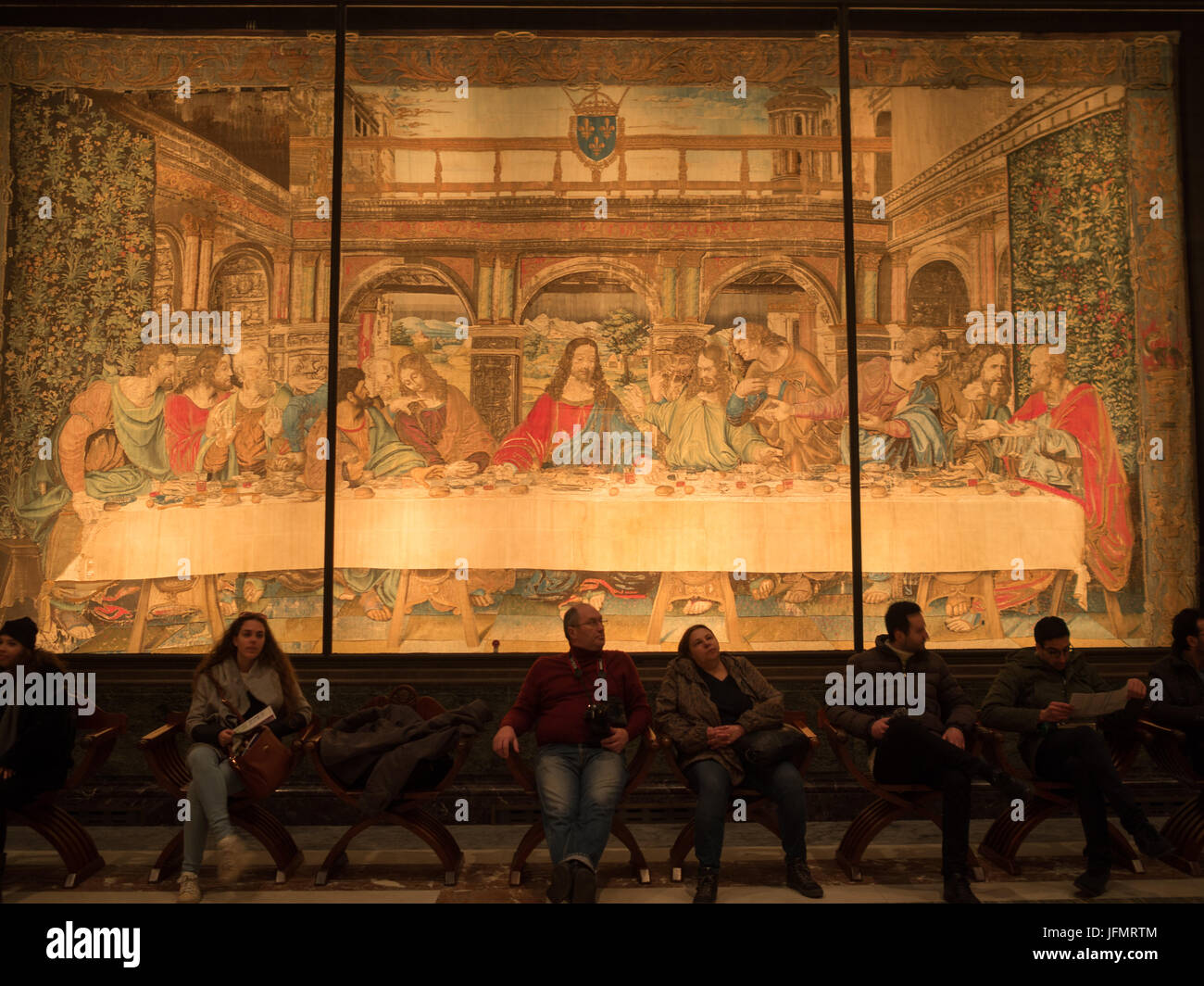 Vatican Museum visitors seated resting in front of a Last Supper tapestry Stock Photo
