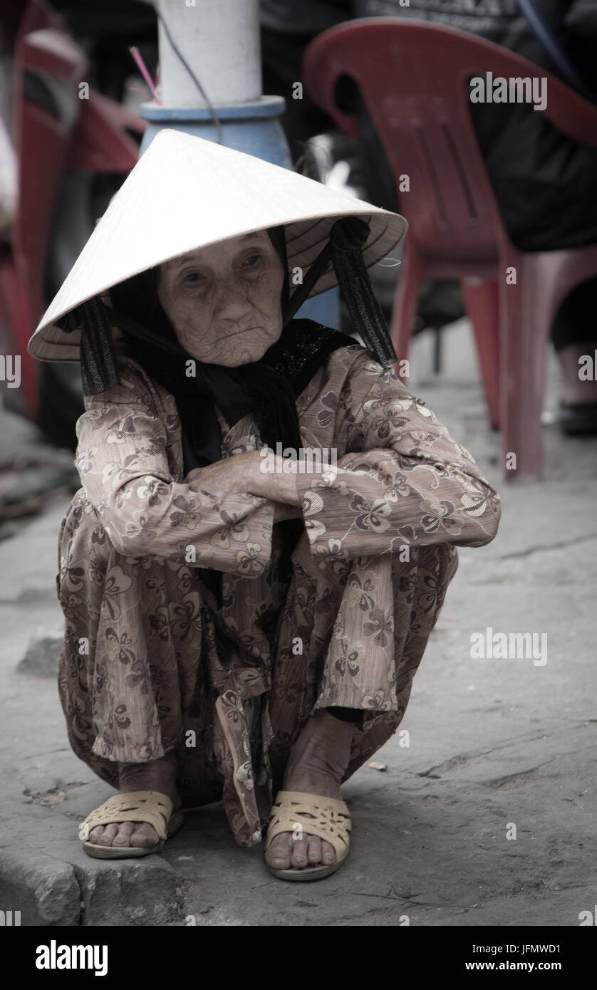 Elderly Vietnamese Woman Sitting in the Street Stock Photo
