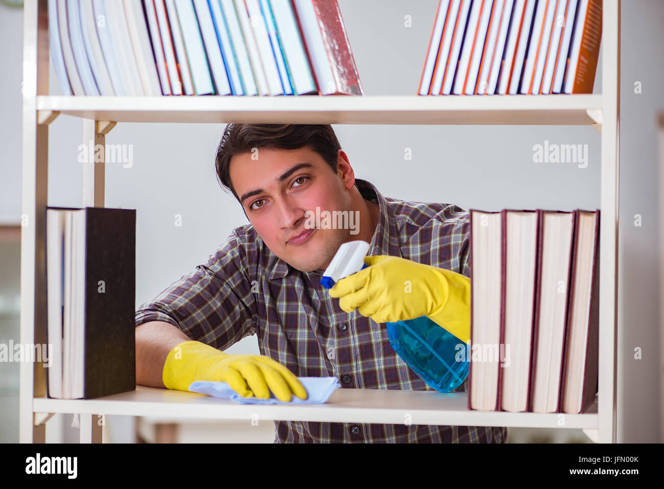 The man cleaning dust from bookshelf Stock Photo Alamy