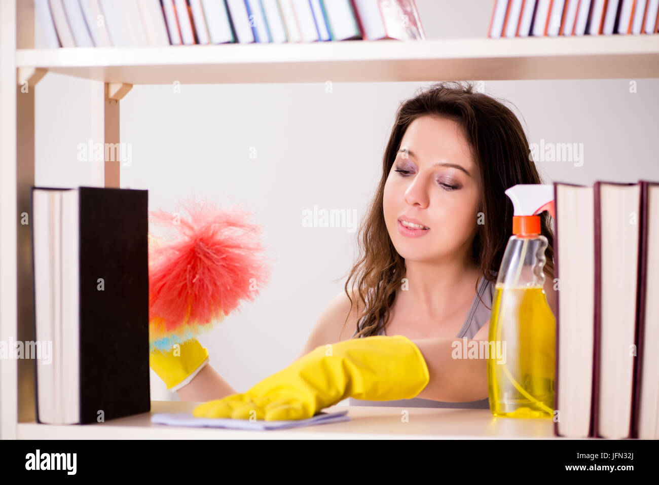 The woman cleaning dust from bookshelf Stock Photo Alamy