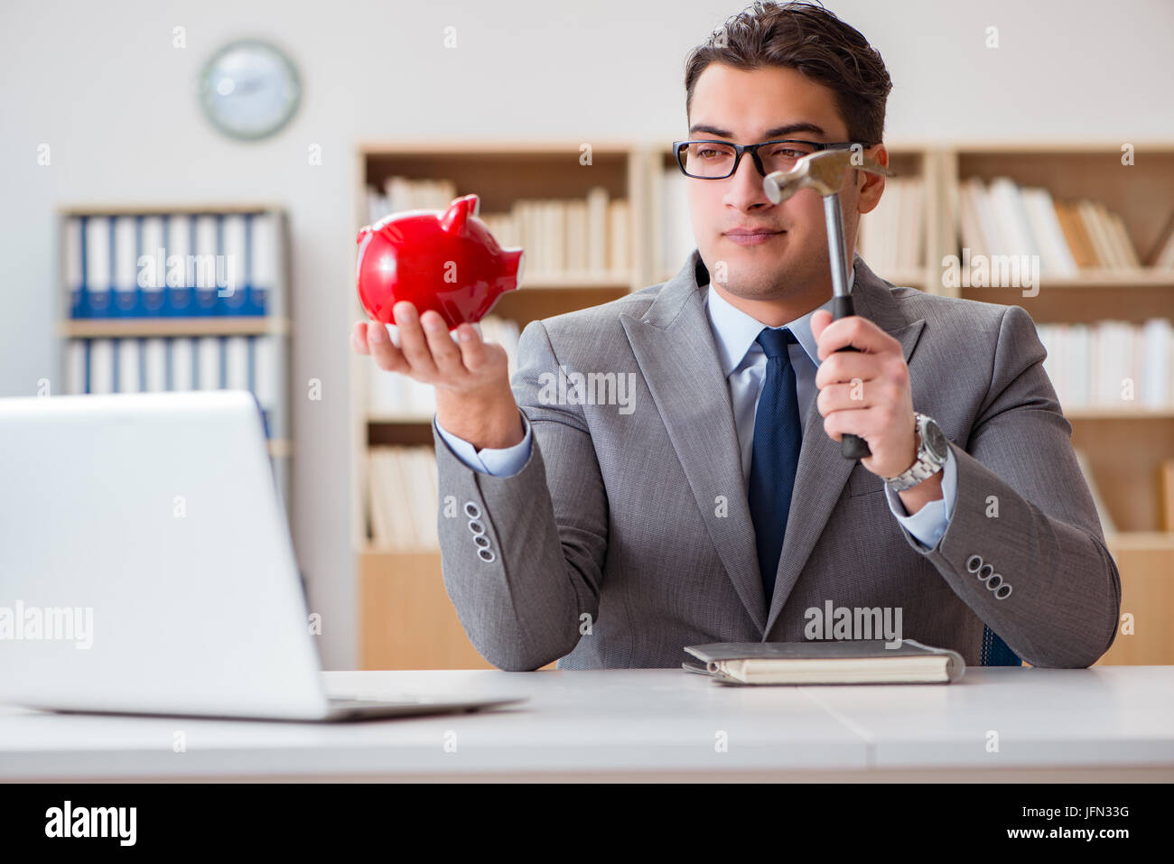 The businessman in search of his savings with piggy bank Stock Photo ...