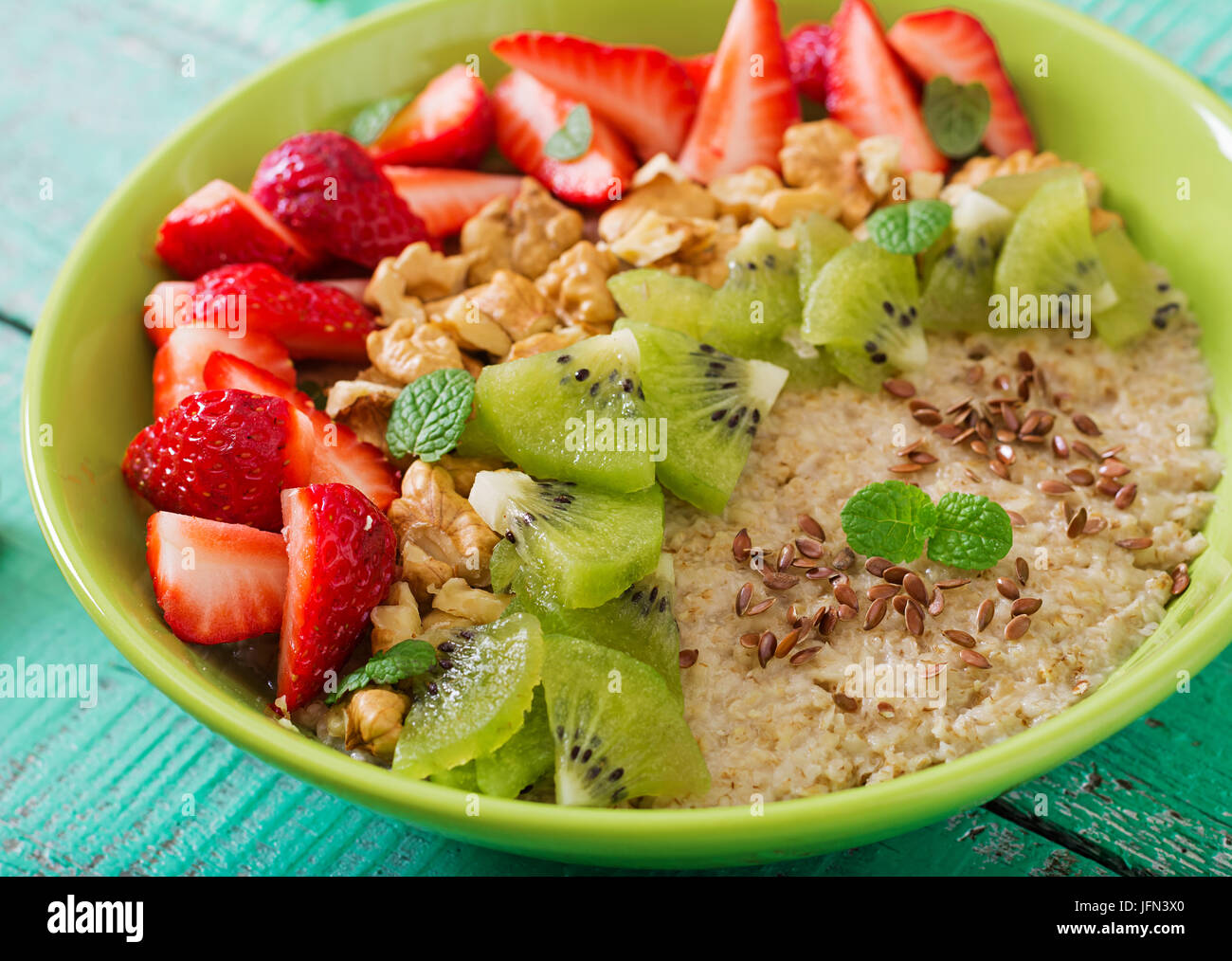 Tasty and healthy oatmeal porridge with berry, nuts and flax seeds