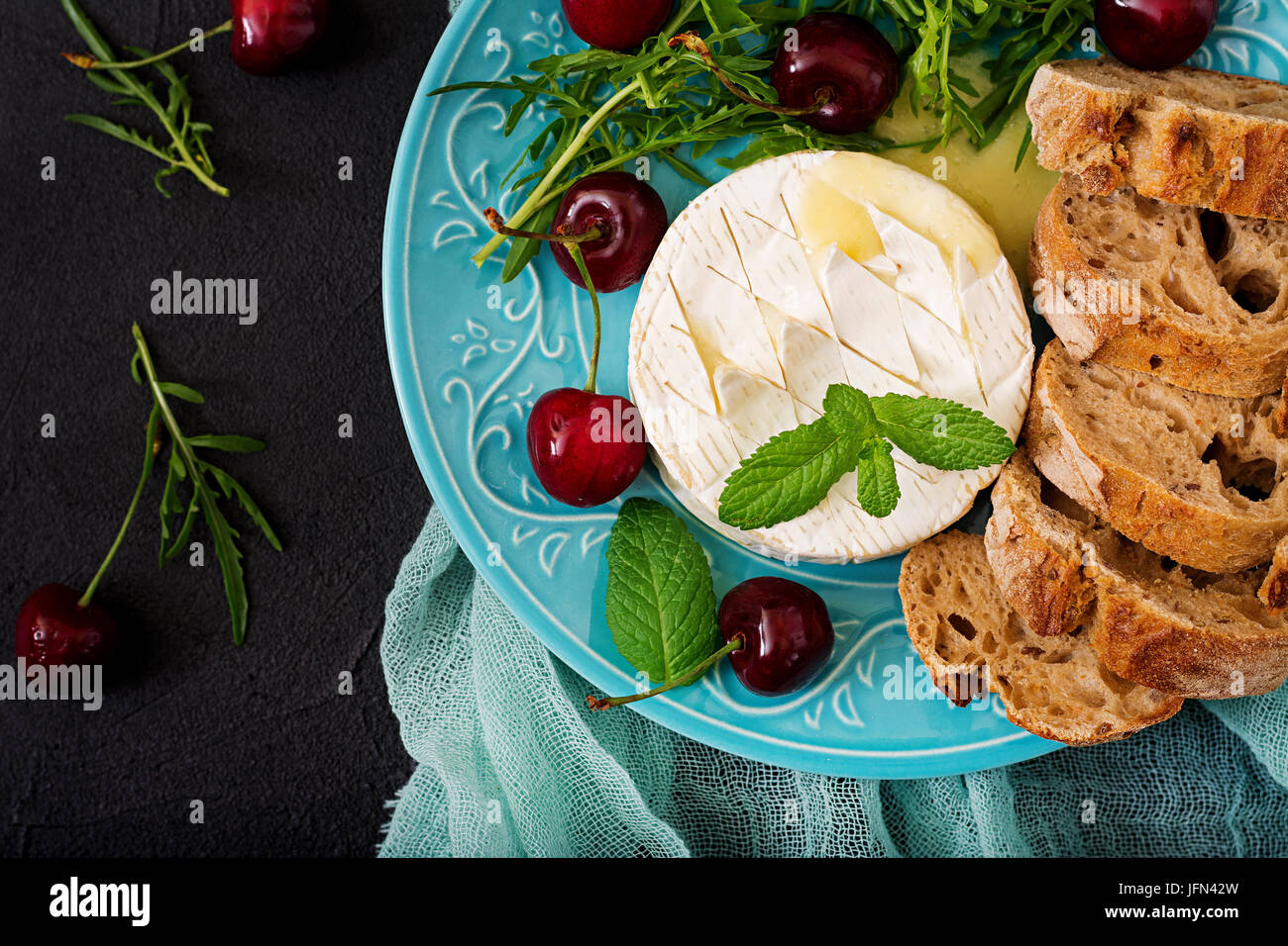 Baked Camembert cheese, toast and arugula salad with sweet cherries ...