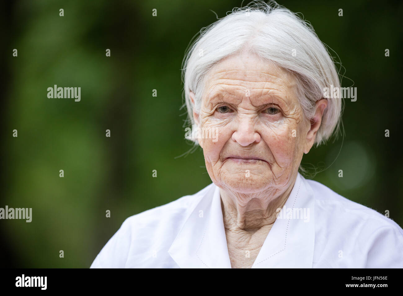 Portrait of smiling senior woman outdoors looking at camera Stock Photo ...