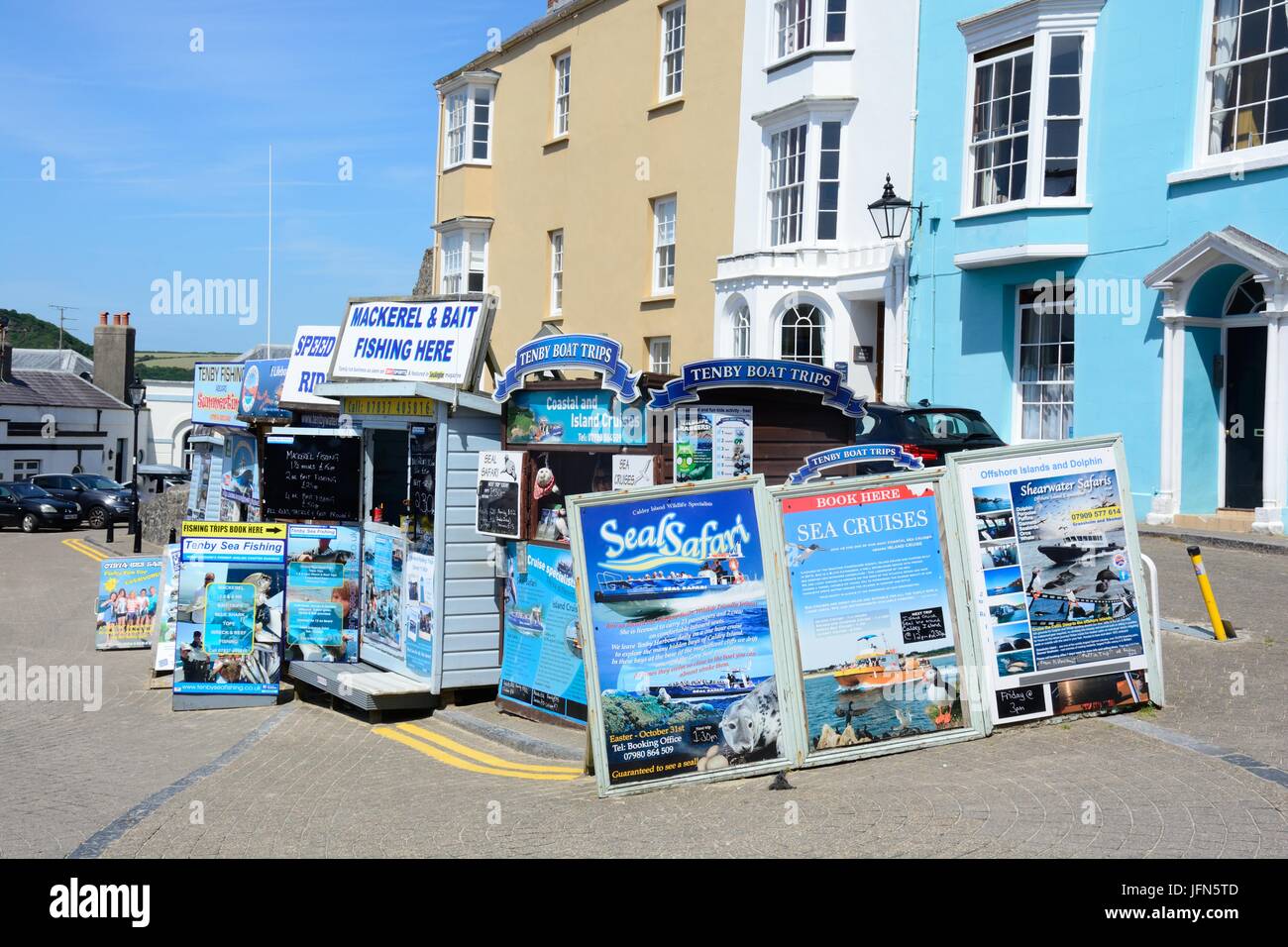 Huts posters signs advertising boat and fishing trips Tenby Wales Cymru UK GB Stock Photo