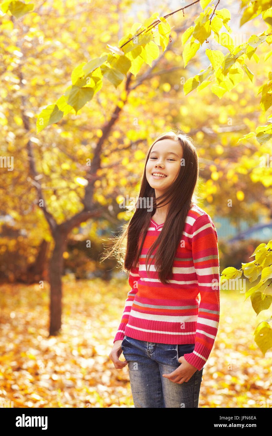 closeup portrait of a beautiful smiling teenage girl with yellow leaves ...