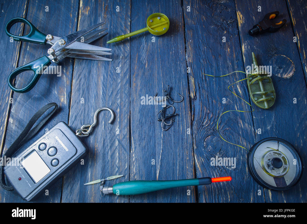 Fishing accessories are rooted all around. Space in the center. Copyspace. Stock Photo