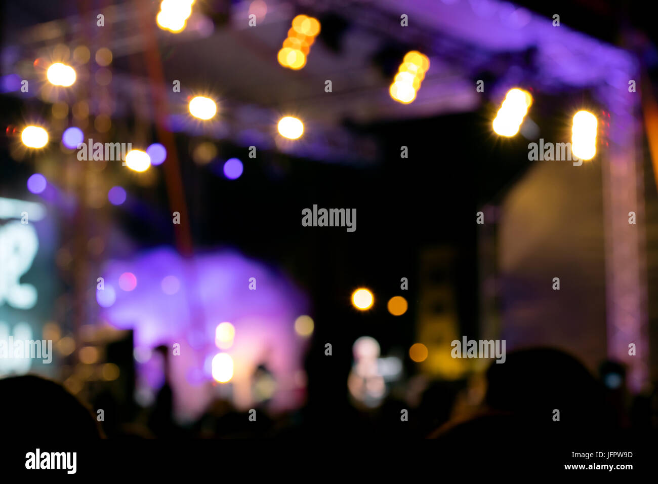 blurred lights of outdoor stage. silhouette of crowd at music concert. Stock Photo
