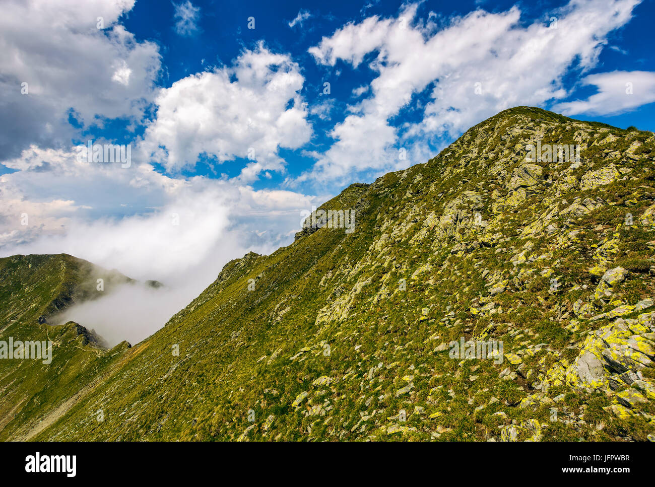 edge of steep slope on rocky hillside in foggy weather. dramatic scenery in mountains Stock Photo