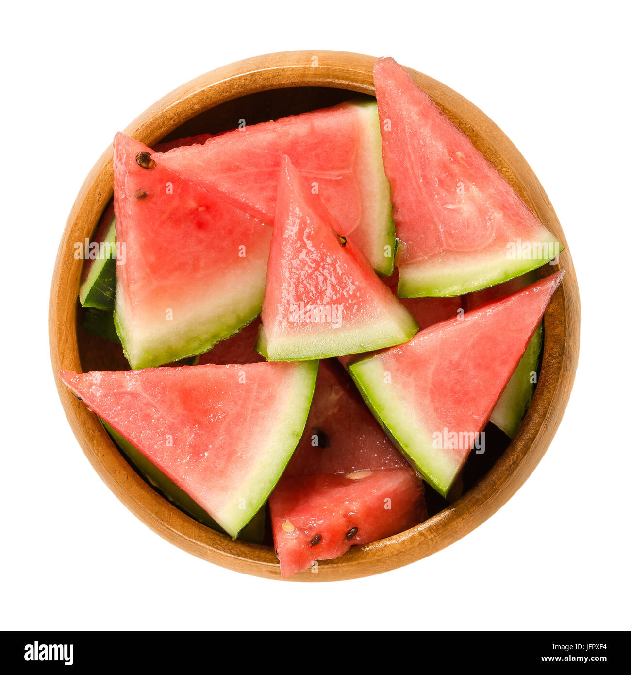 Watermelon slices in wooden bowl. Triangular pieces of raw Citrullus lanatus. Edible fruit with green hard rind, black seeds and red, sweet flesh. Stock Photo