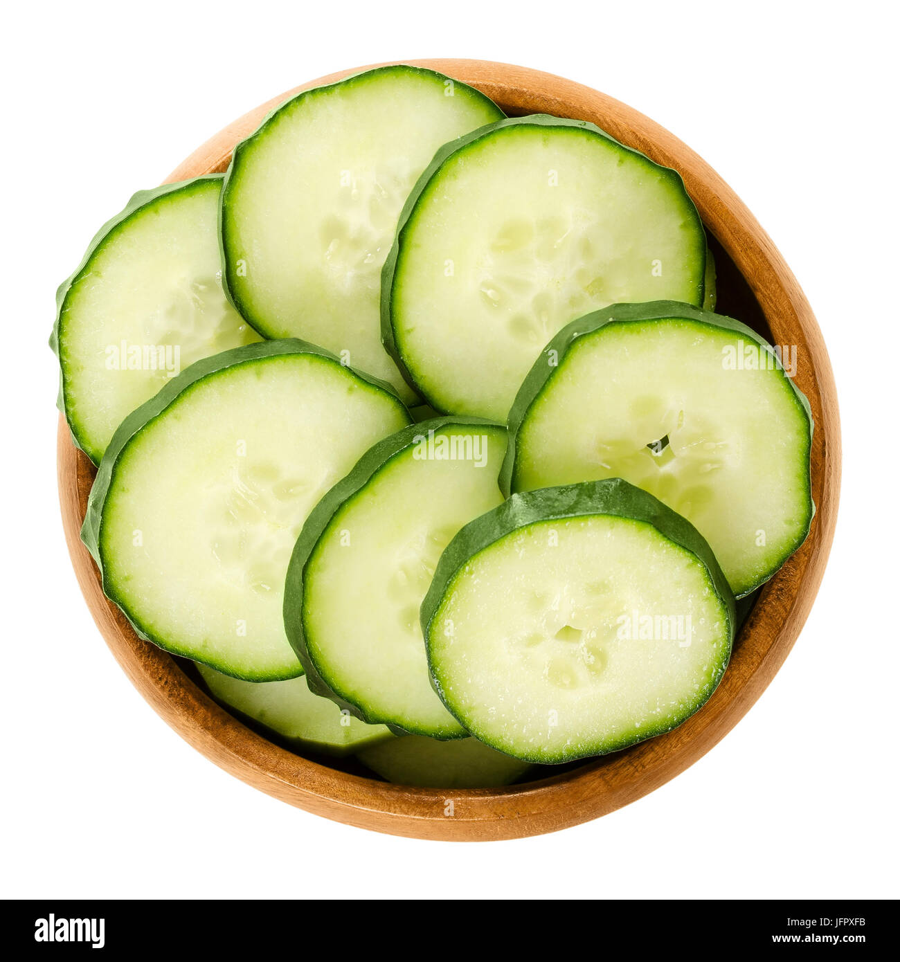 Cucumber slices in wooden bowl. Cucumis sativus. Sliced seedless vegetable, fresh and unripe with green skin. Isolated macro food photo close up. Stock Photo