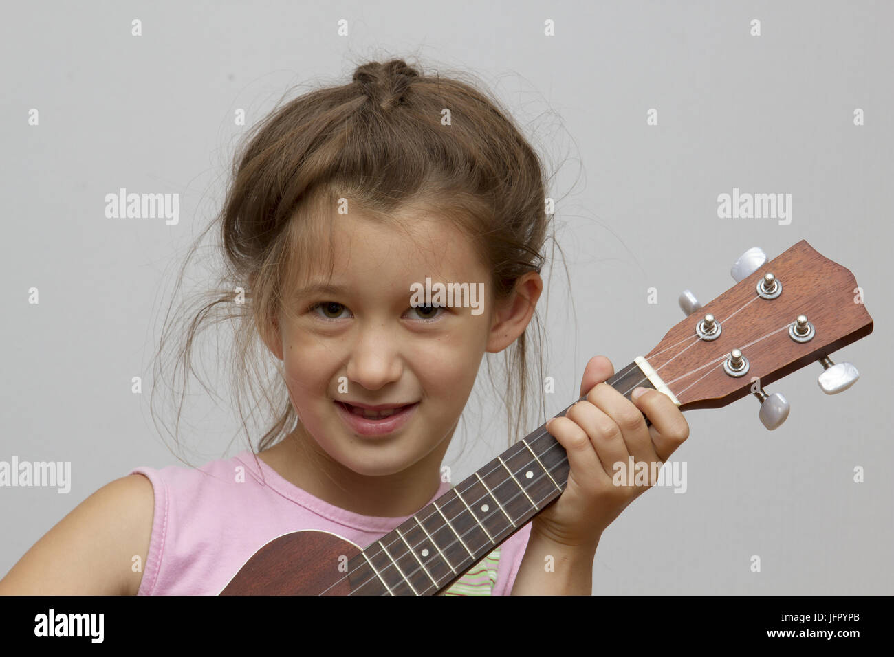 Little girl playing ukulele Stock Photo Alamy