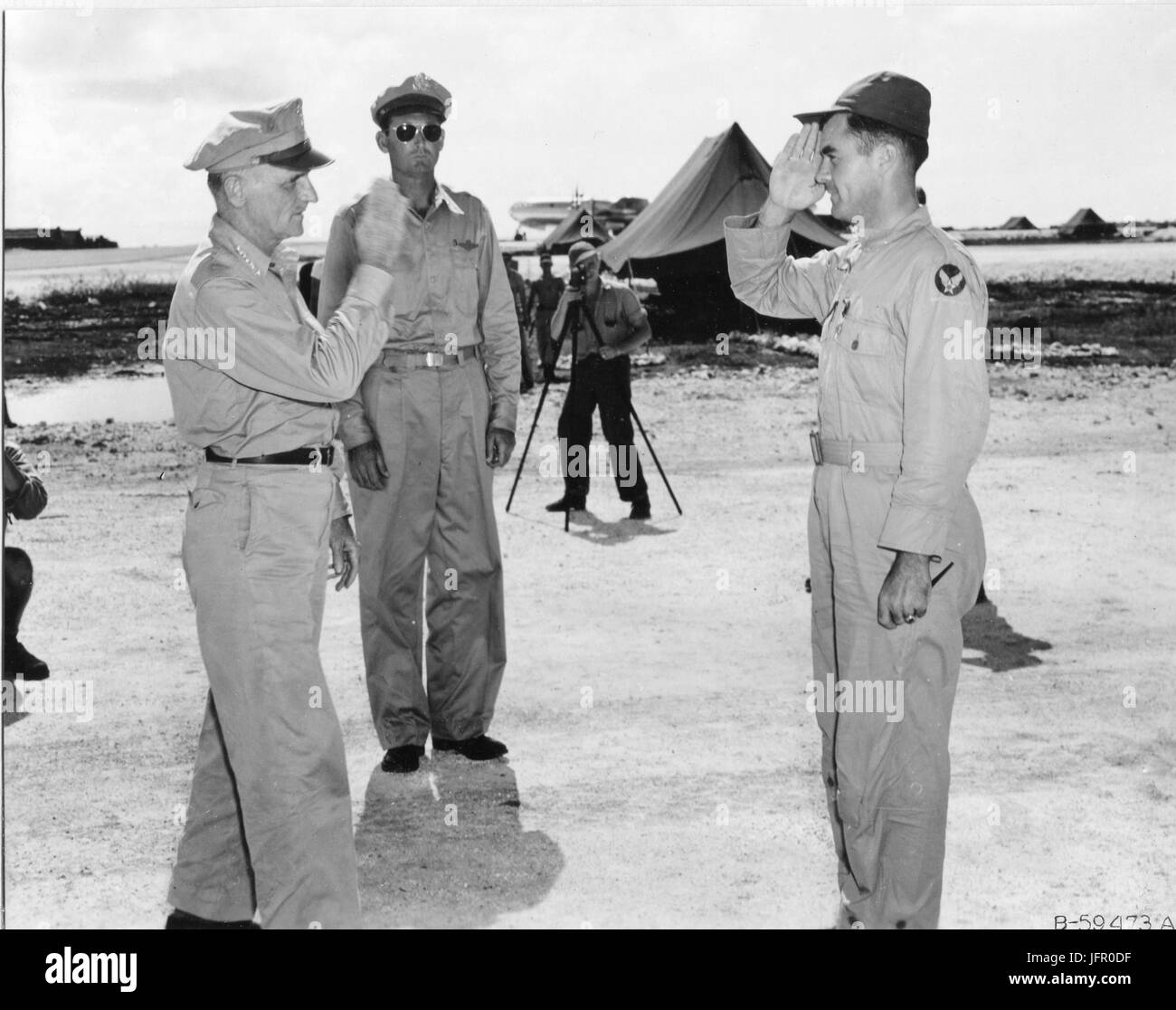 General Carl A. Spaatz saluting Col Paul W. Tibbets after presenting him with the Distinguished Service Cross. Tibbets is the pilot of the B-29 ENOLA GAY which atom bombed Hiroshima, Japan. In the background is General Davies of the 313th Wing. Marianas Islands, 1945. Stock Photo