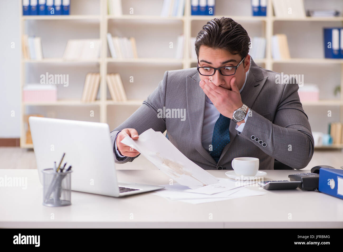 The businessman spilling coffee on important documents Stock Photo