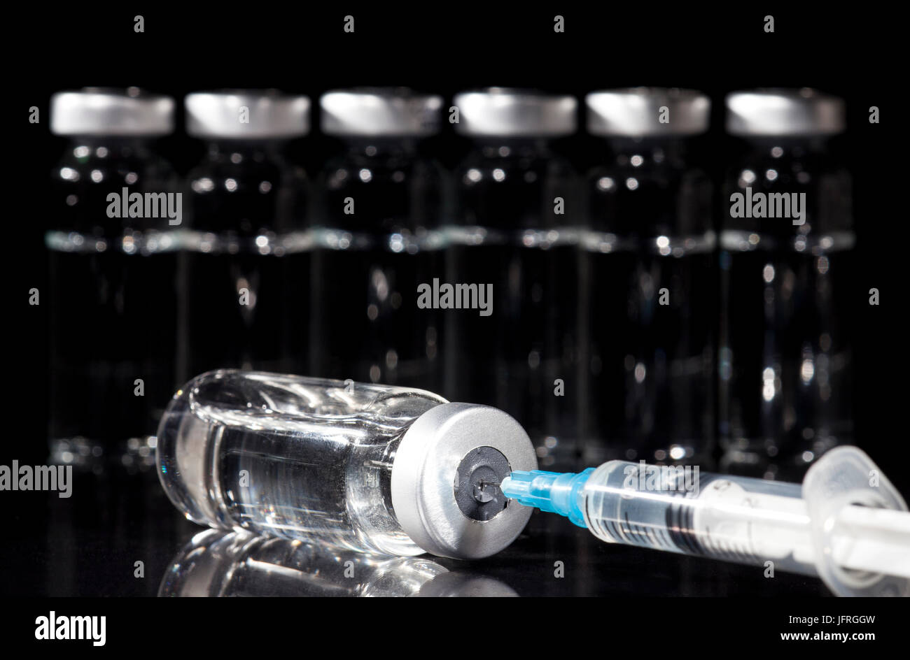Glass Medicine Vials and Syringe on black background Stock Photo - Alamy