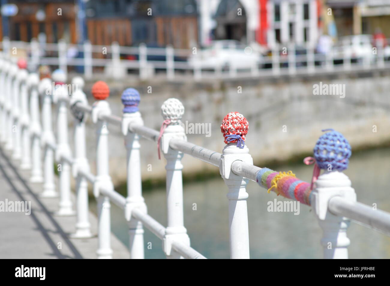 Knitted covers on railings on Ramsgate harbour wall Stock Photo