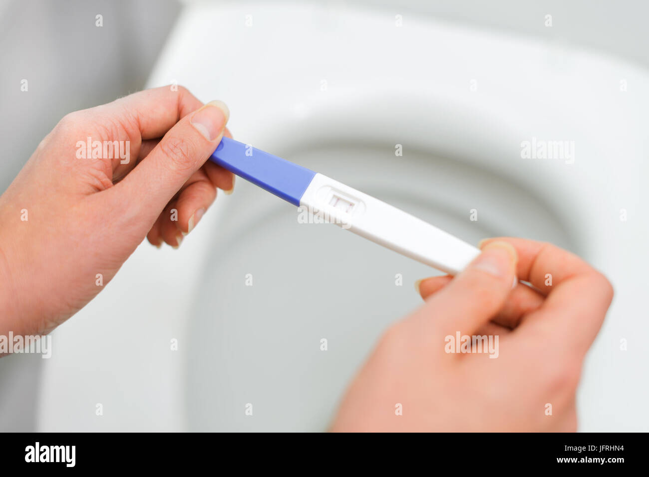 Woman holding positive pregnancy test. Stock Photo