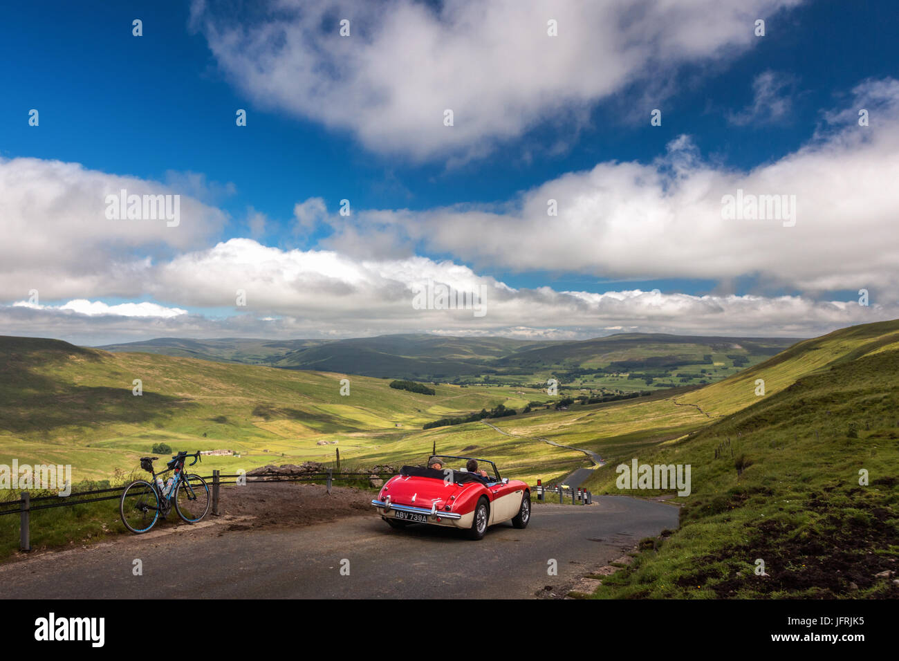 Views from top of Fleet Moss with road bike & red Austin Healey 3000 car - famous cycling hill climb & countryside drive, Hawes, Yorkshire Dales, UK Stock Photo
