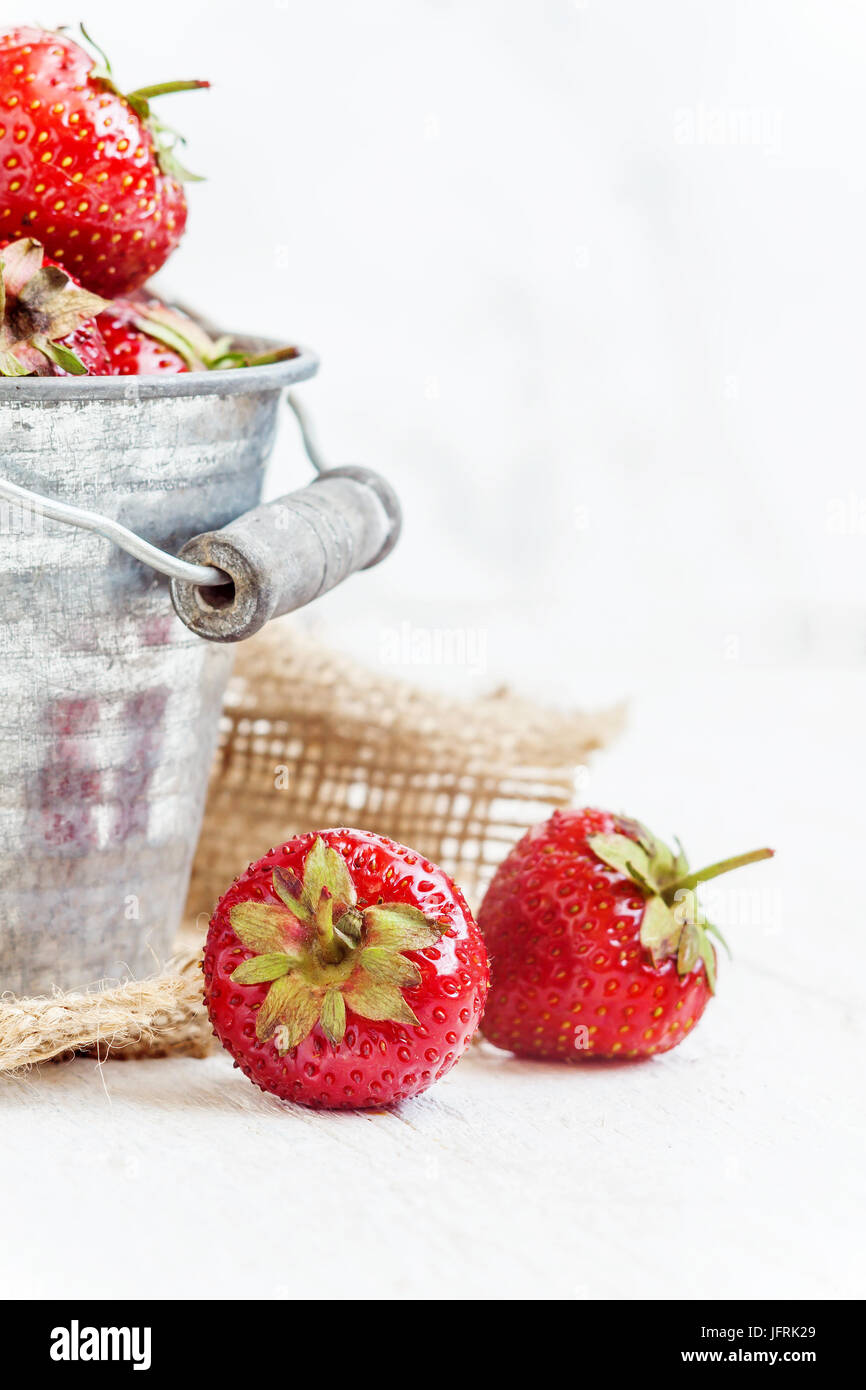Fresh juicy strawberries in an old iron bucket on a white background ...
