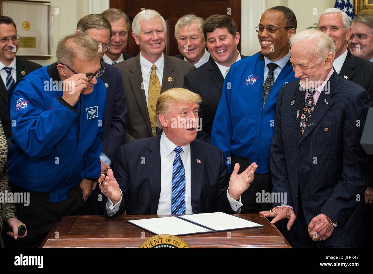 U.S President Donald Trump surrounded by members of the Congress, Astronauts, and Commercial Space Companies comments before signing an Executive Order to reestablish the National Space Council in the Roosevelt room of the White House June 30, 2017 in Washington, DC. Vice President Mike Pence, also in attendance, will chair the council. Also pictured are retired NASA astronaut David Wolf, left, Astronaut Alvin Drew, second from right, and retired NASA astronaut legend Buzz Aldrin, right. Stock Photo