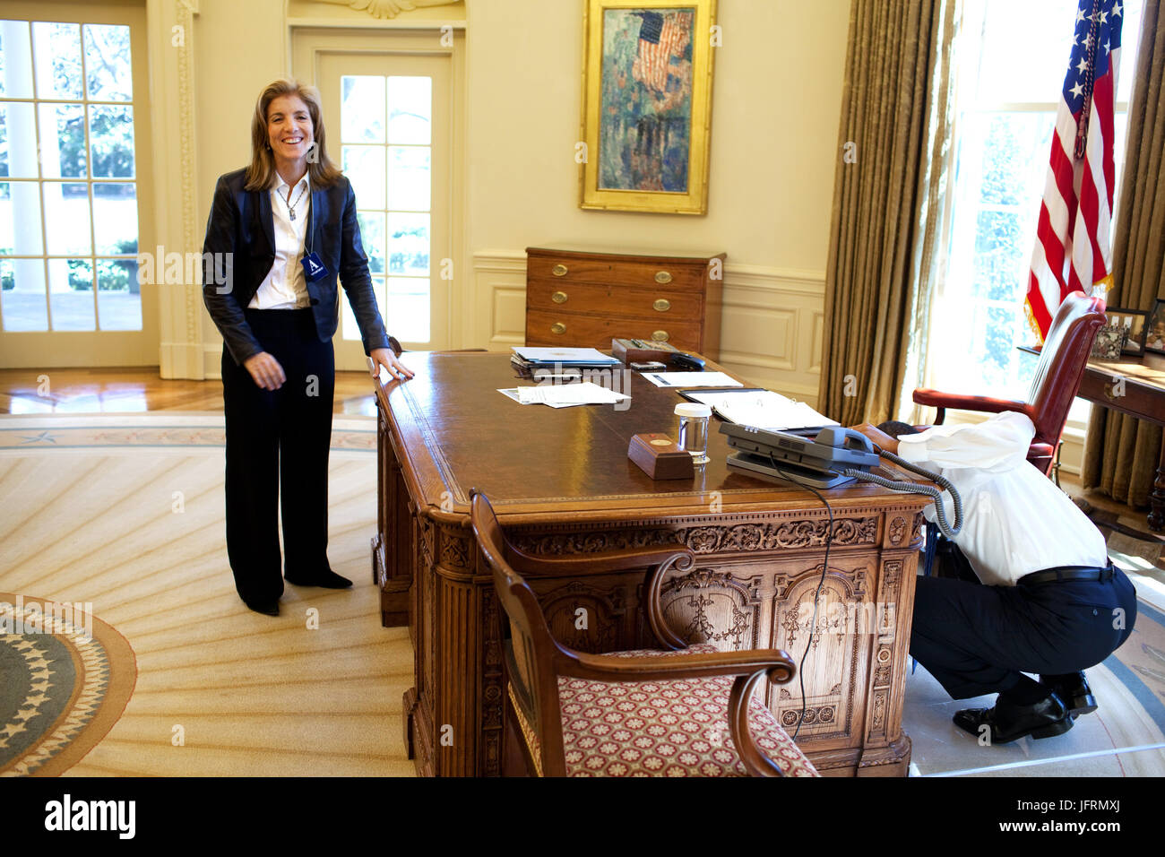 President Barack Obama examines  the Resolute Desk on March 3, 2009, while visiting with Caroline Kennedy Schlossberg in the Oval Office. In a famous photograph, her brother John F. Kennedy Jr., peeked through the FDR panel, while his father President Kennedy worked.  Official White House Photo by Pete Souza Stock Photo