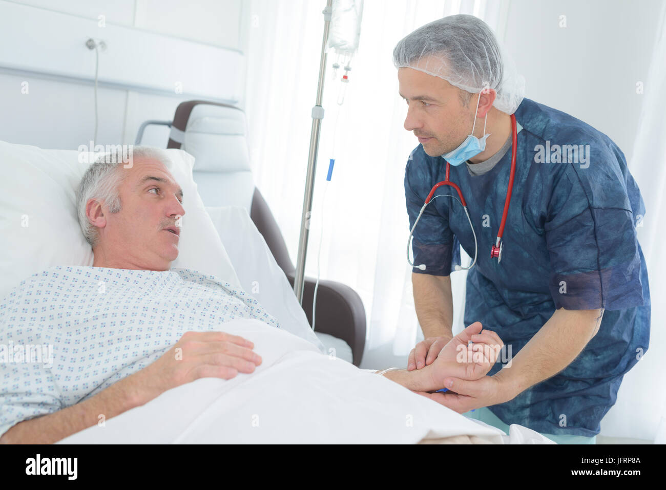 friendly male doctor hold patient hand in hospital room Stock Photo Alamy