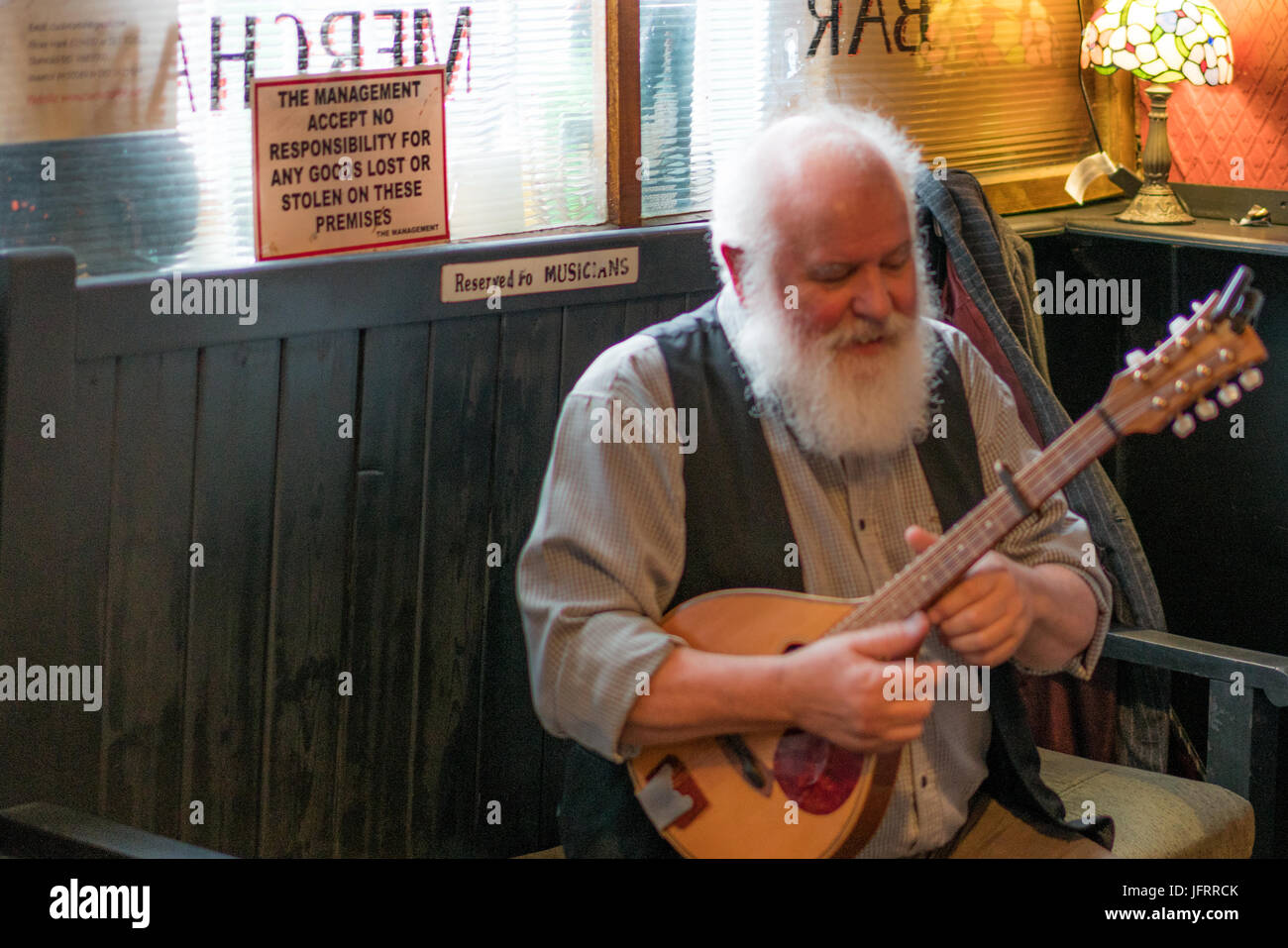 A mandolin player with white beard in a Irish traditional session music