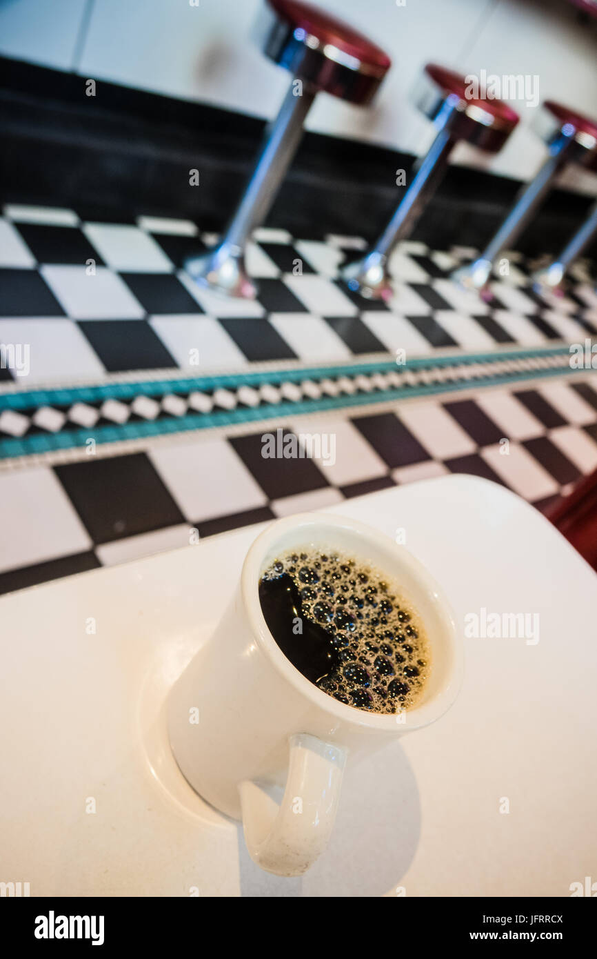 Detail Of A Coffee Cup And Counter Stools In A Retro USA Diner Stock Photo
