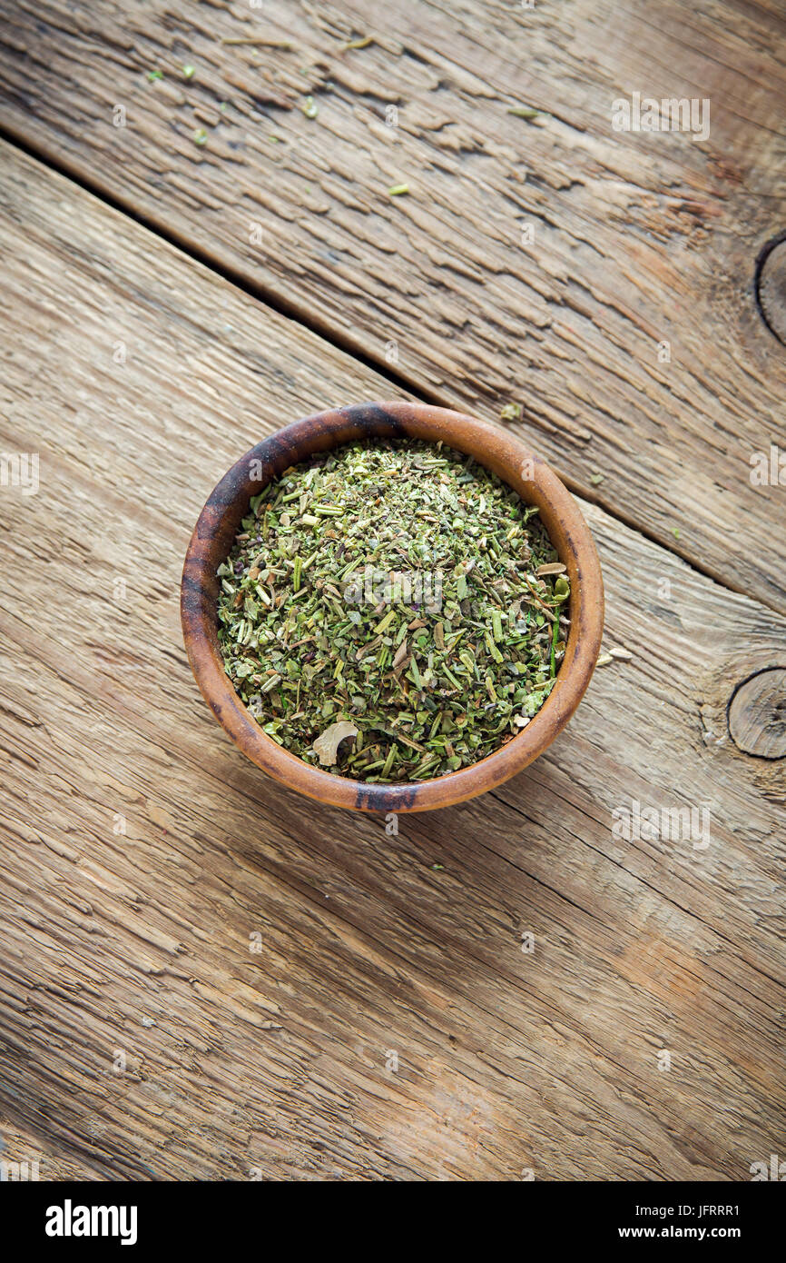 Mixed Italian Herbs Seasoning on wooden background, copy space. Dried
