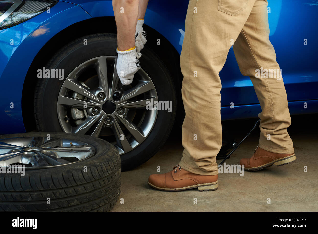 Man changing modern car wheel close-up. Service of repairing car Stock Photo