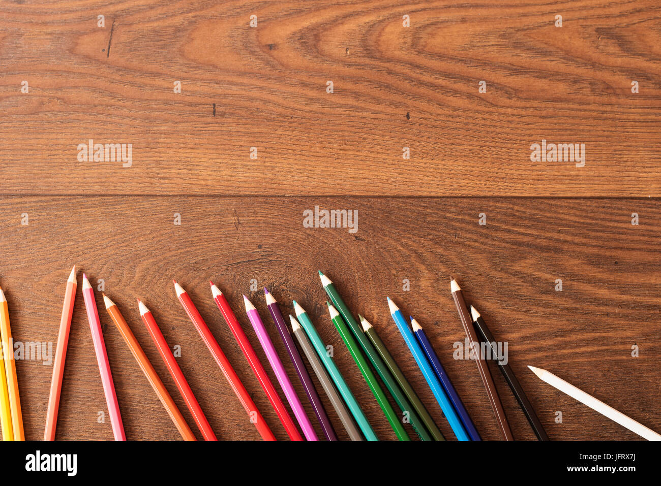 Colorful pencils on the brown wooden table background. Frame of colored ...