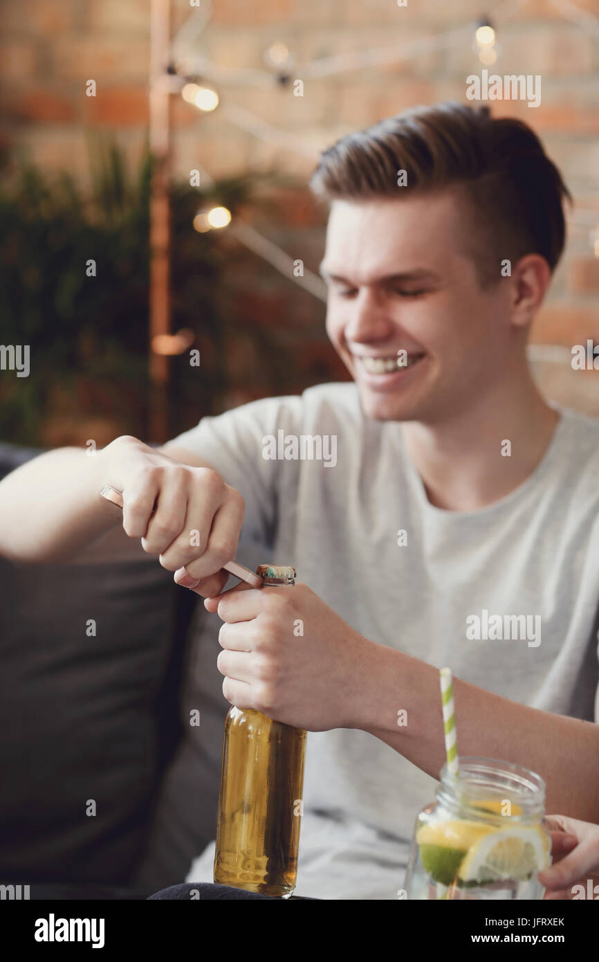 Man opens beer bottle with a phone Stock Photo