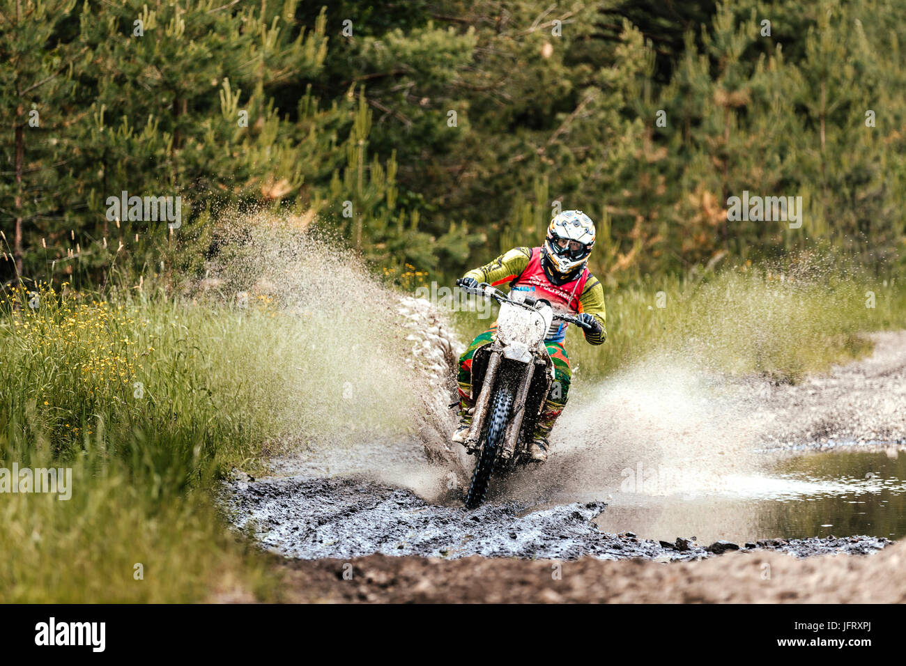enduro athlete on motorcycle crosses a water puddle during Ural Cup in Enduro Stock Photo