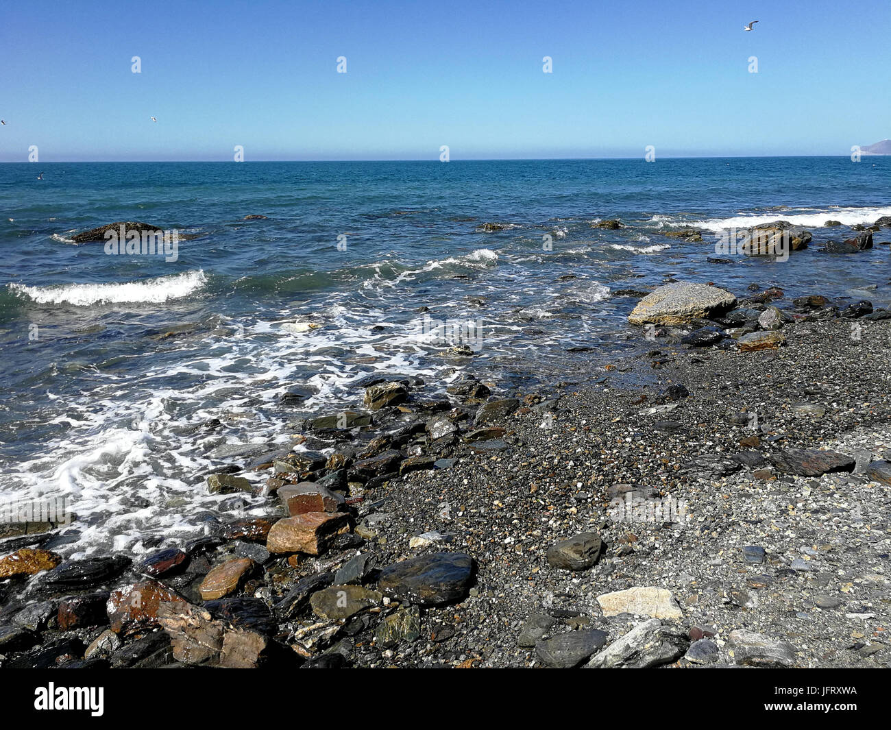 Beach with rocks and soft waves Stock Photo