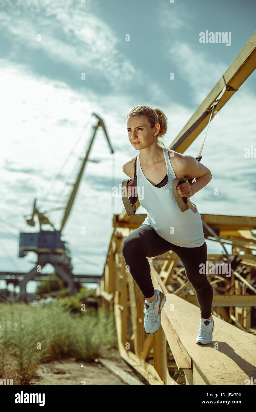 Cheerful woman exercising with suspension trainer outdoor Stock Photo Alamy