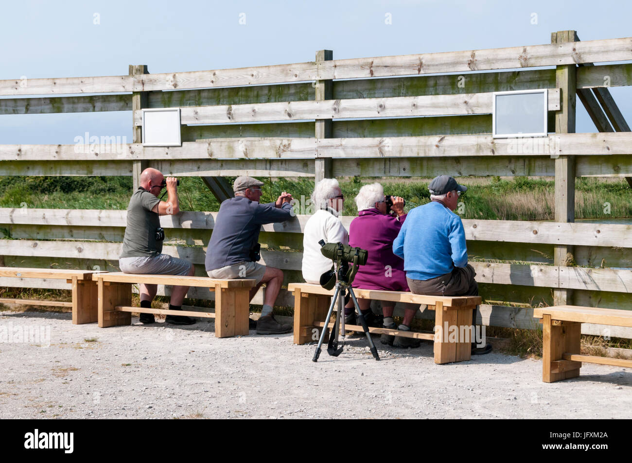 Bird watchers at the Fen Hide overlooking the Freshwater Marsh at RSPB Titchwell Marsh bird reserve on the North Norfolk coast. Stock Photo