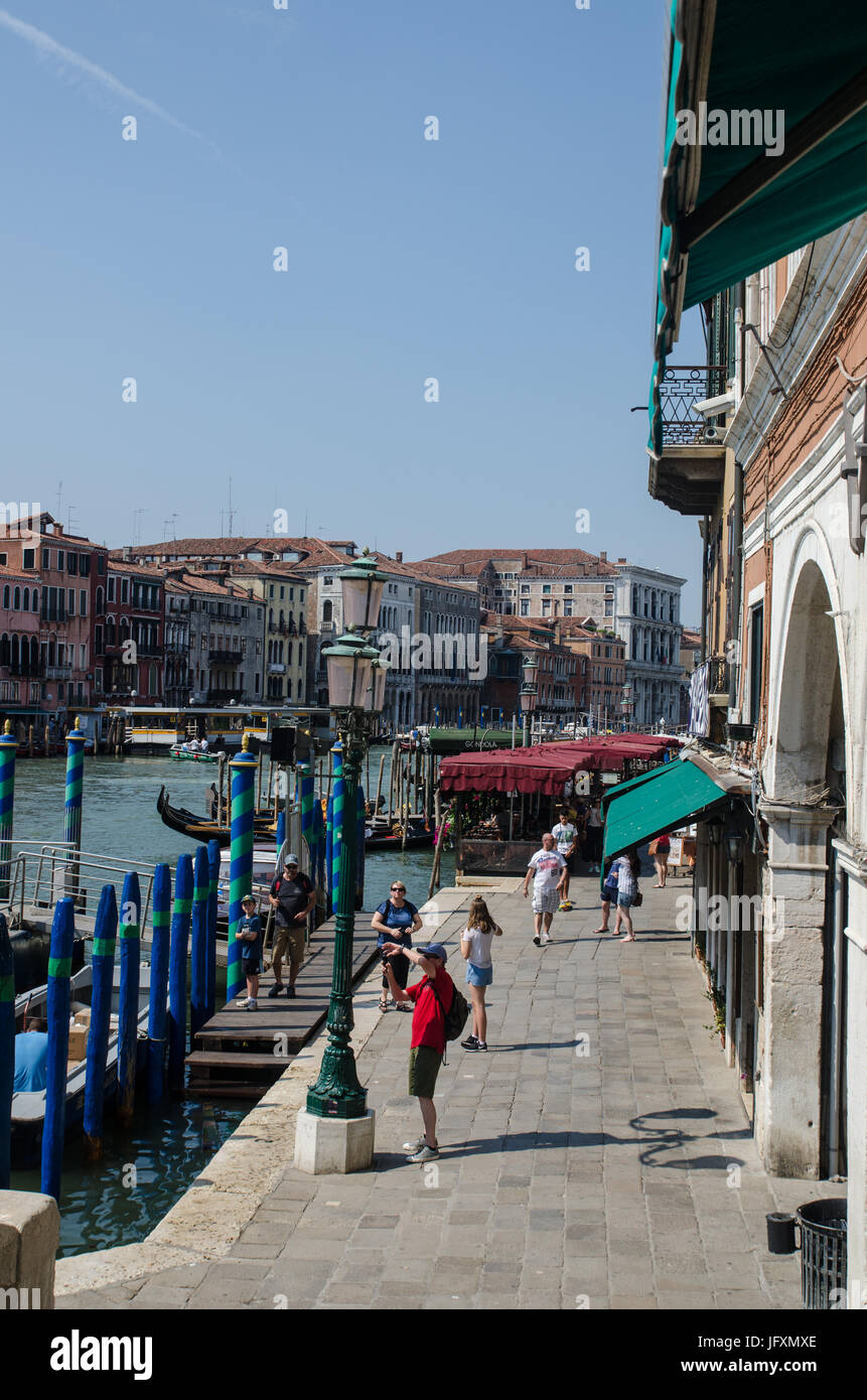 Tourists and waterside restaurants on the Riva del Vin by the Grand Canal in Venice, Italy Stock Photo