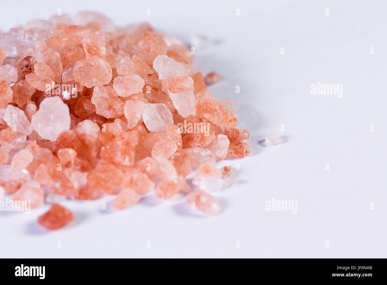 Himalayan pink salt crystals piled and isolated on a white background ...
