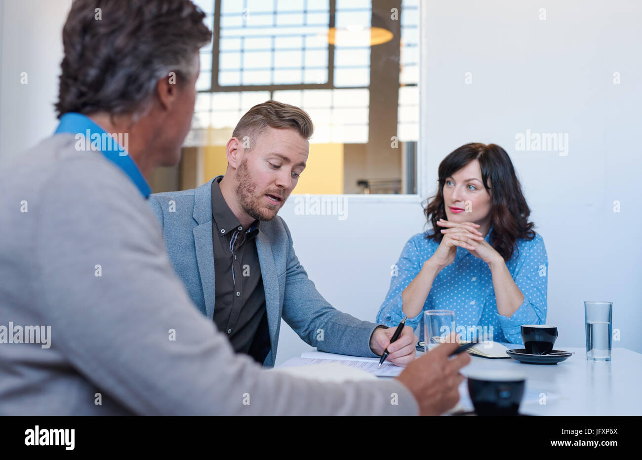Three business colleagues having a meeting together in an office Stock Photo