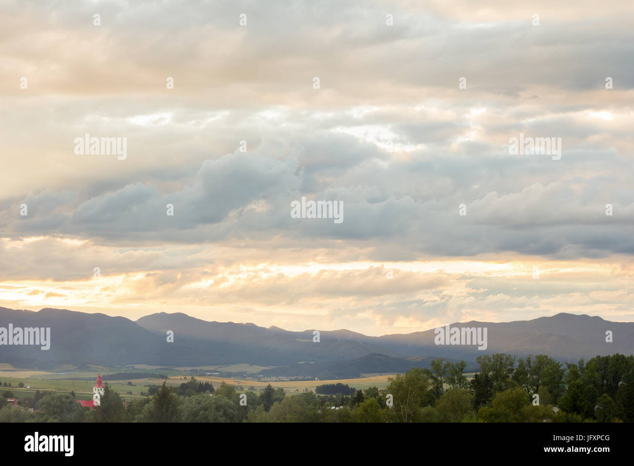 dramatic overcast sky cloudscape sunset in mountains Stock Photo