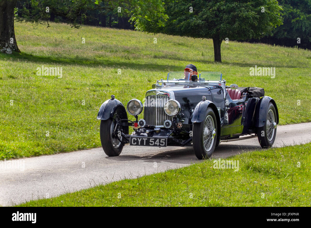 1936 30S blue pre-war Aston Martin; Classic, collectable restored vintage vehicles being driven in woodland park, UK Stock Photo