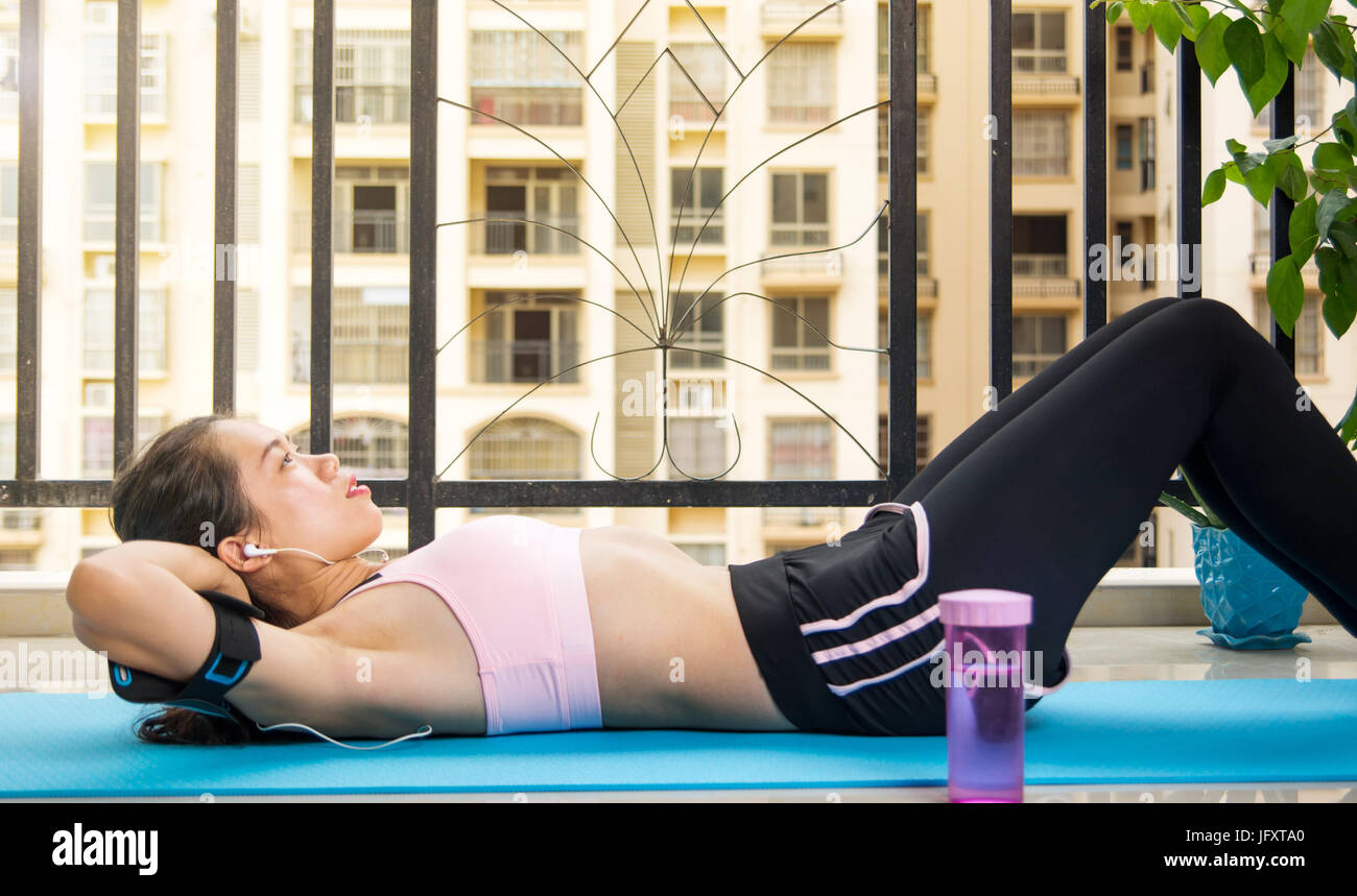 Girl doing crunches on the balcony. Home workout Stock Photo