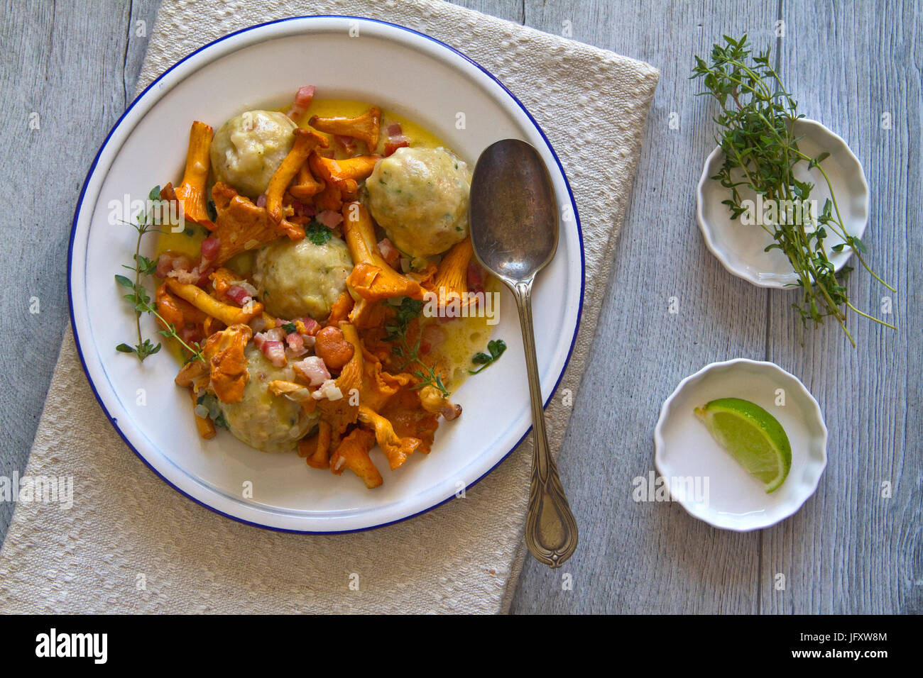 Bread dumplings with chanterelles on a plate with fresh Majoram Stock Photo
