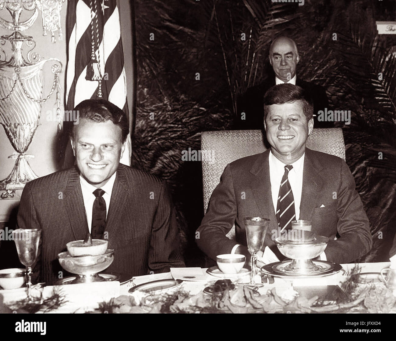 American evangelist Billy Graham and President John F. Kennedy at a prayer breakfast in Washington, D.C. at the The Mayflower Hotel on February 9, 1961. (Photo by Abbie Rowe) Stock Photo
