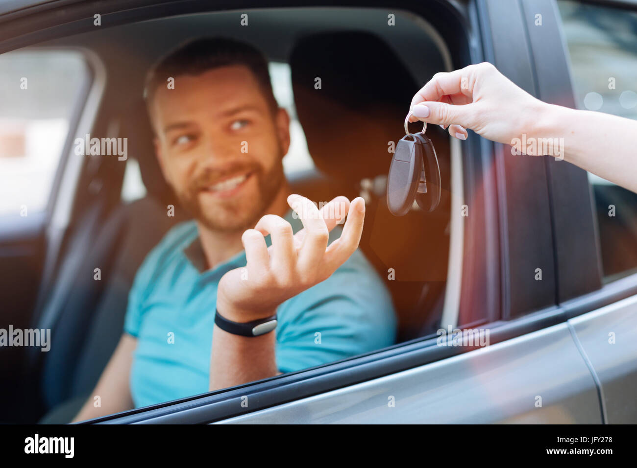 Beautiful bearded man receiving car keys Stock Photo