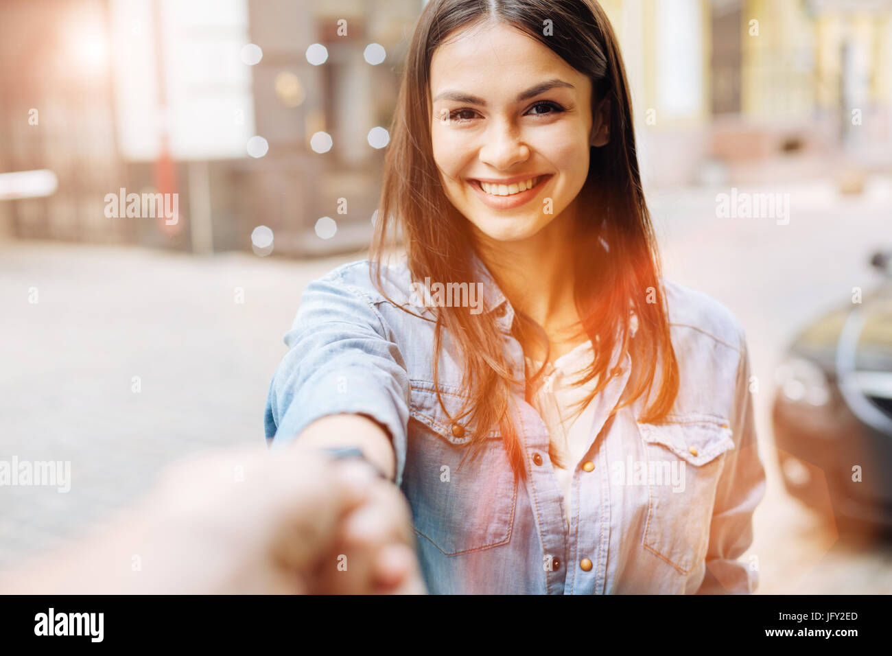 Sweet young woman holding the hand of photographer Stock Photo - Alamy